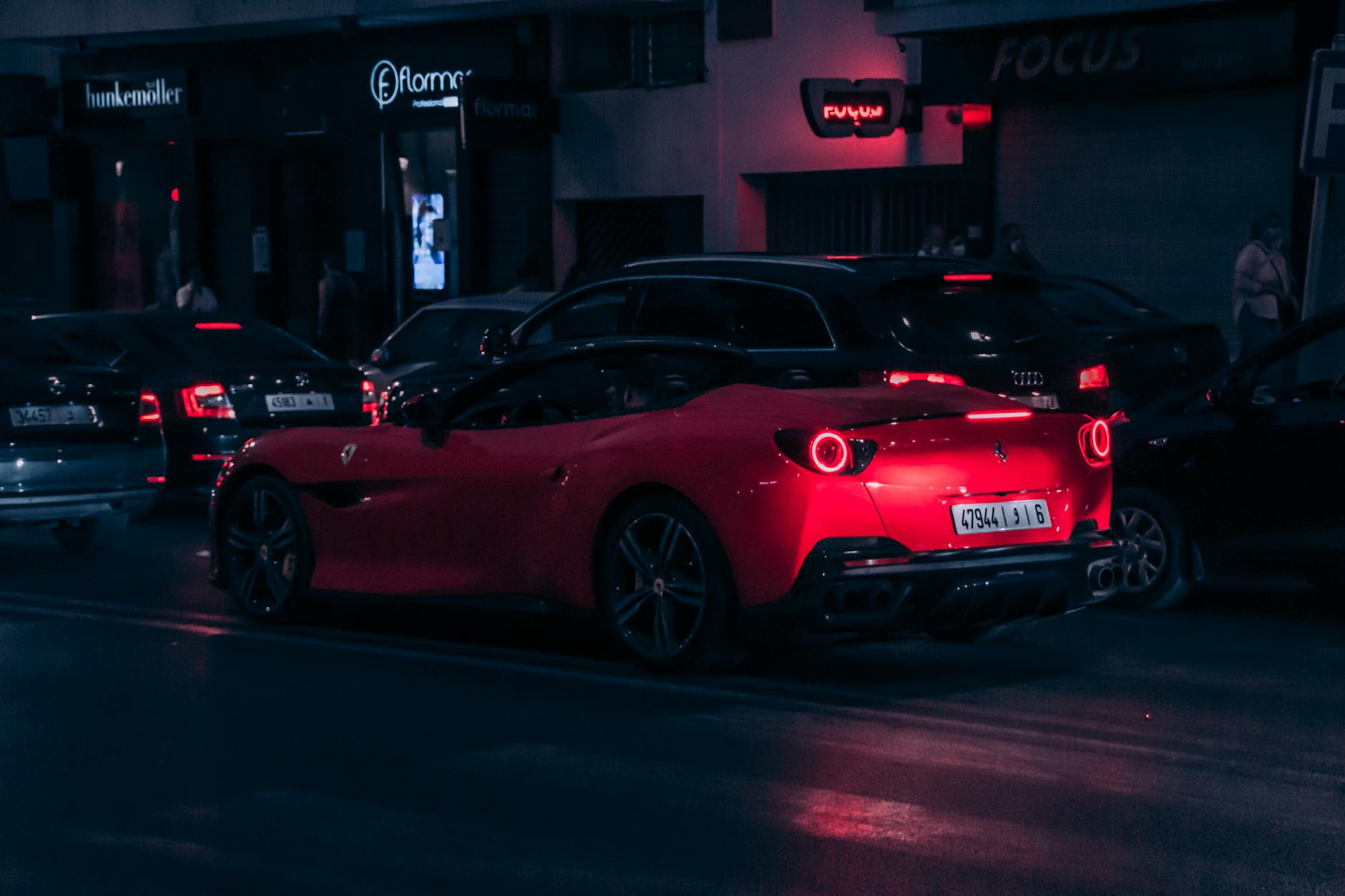 Man checking a phone on a busy Rabat street at night