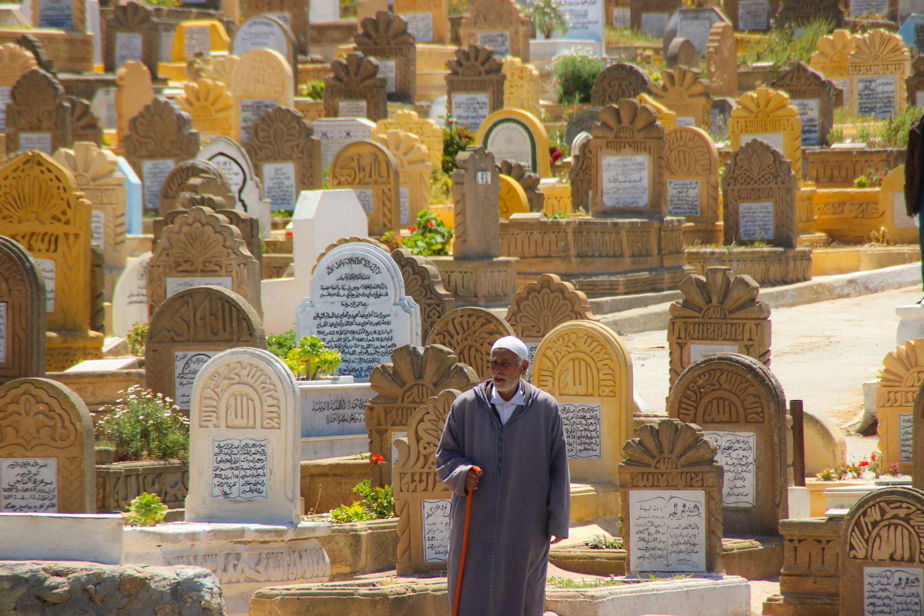 Elderly man among traditional Moroccan tombstones
