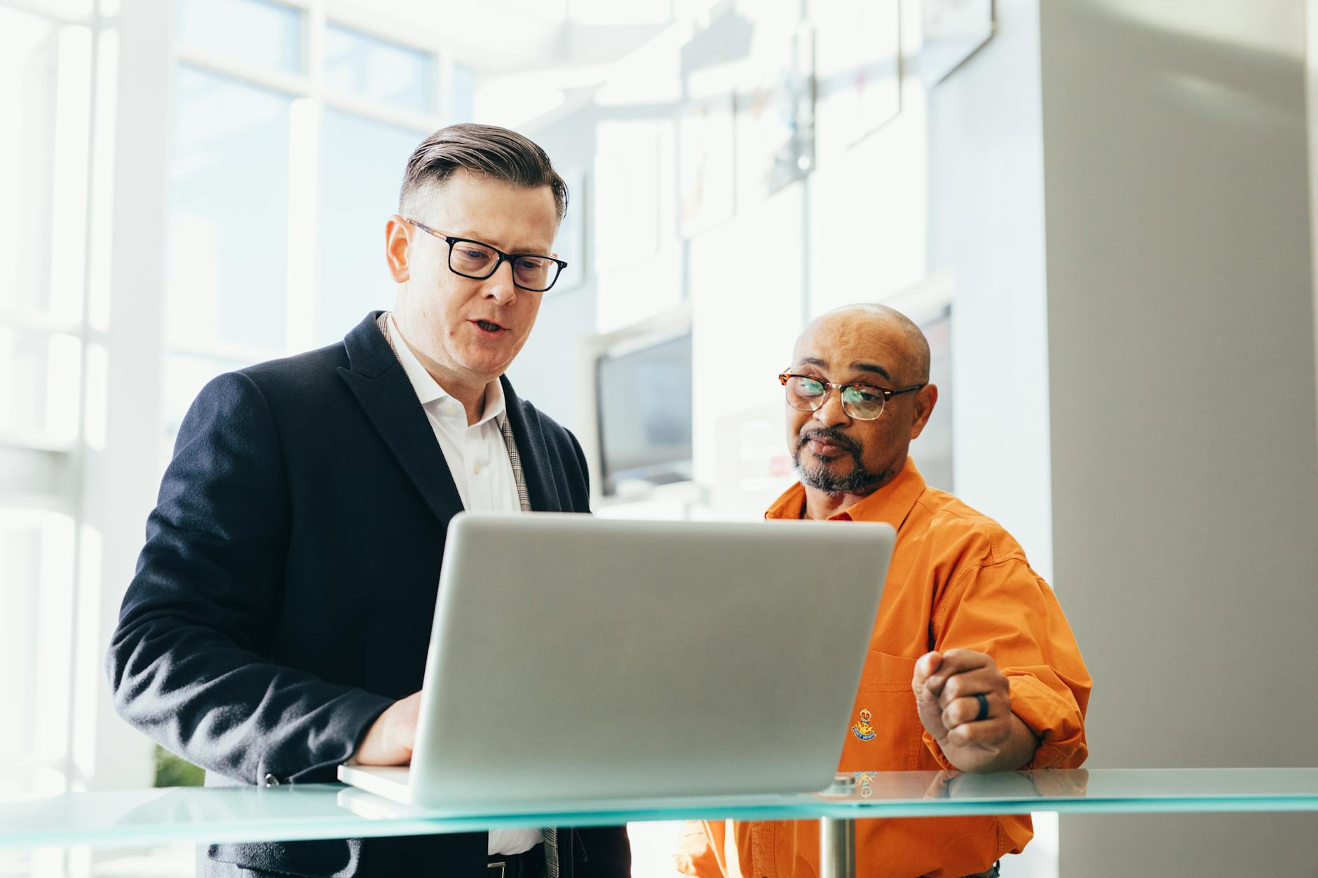 Two business professionals discussing work over a laptop