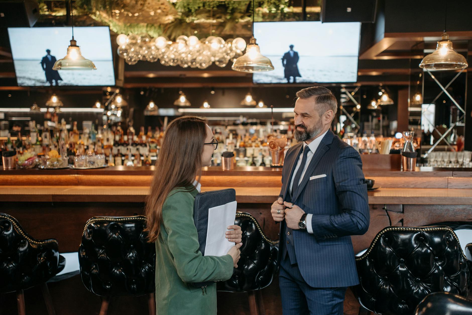 Business meeting between a man and woman at a stylish bar