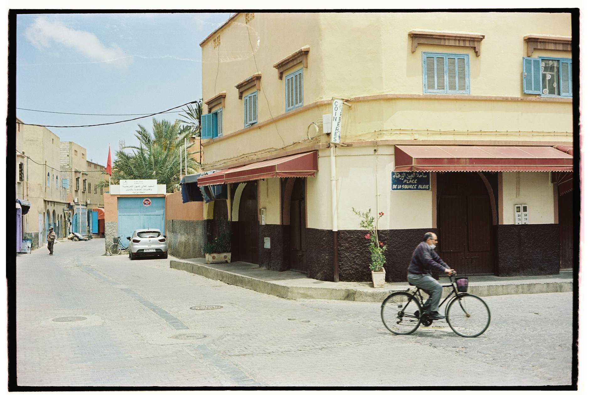 Quiet Moroccan street corner with a cyclist passing old buildings