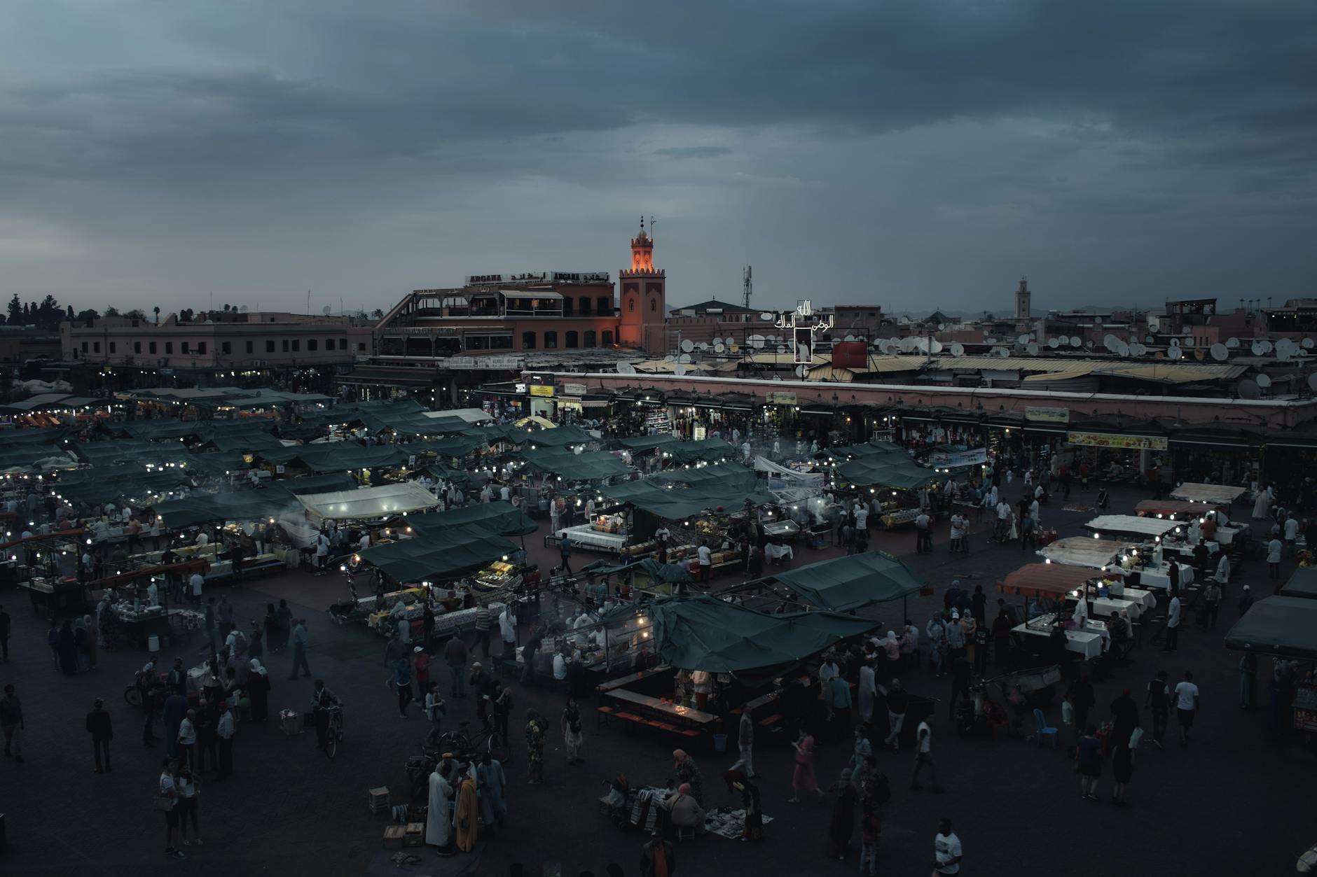Marrakech night market at dusk with crowds and lights
