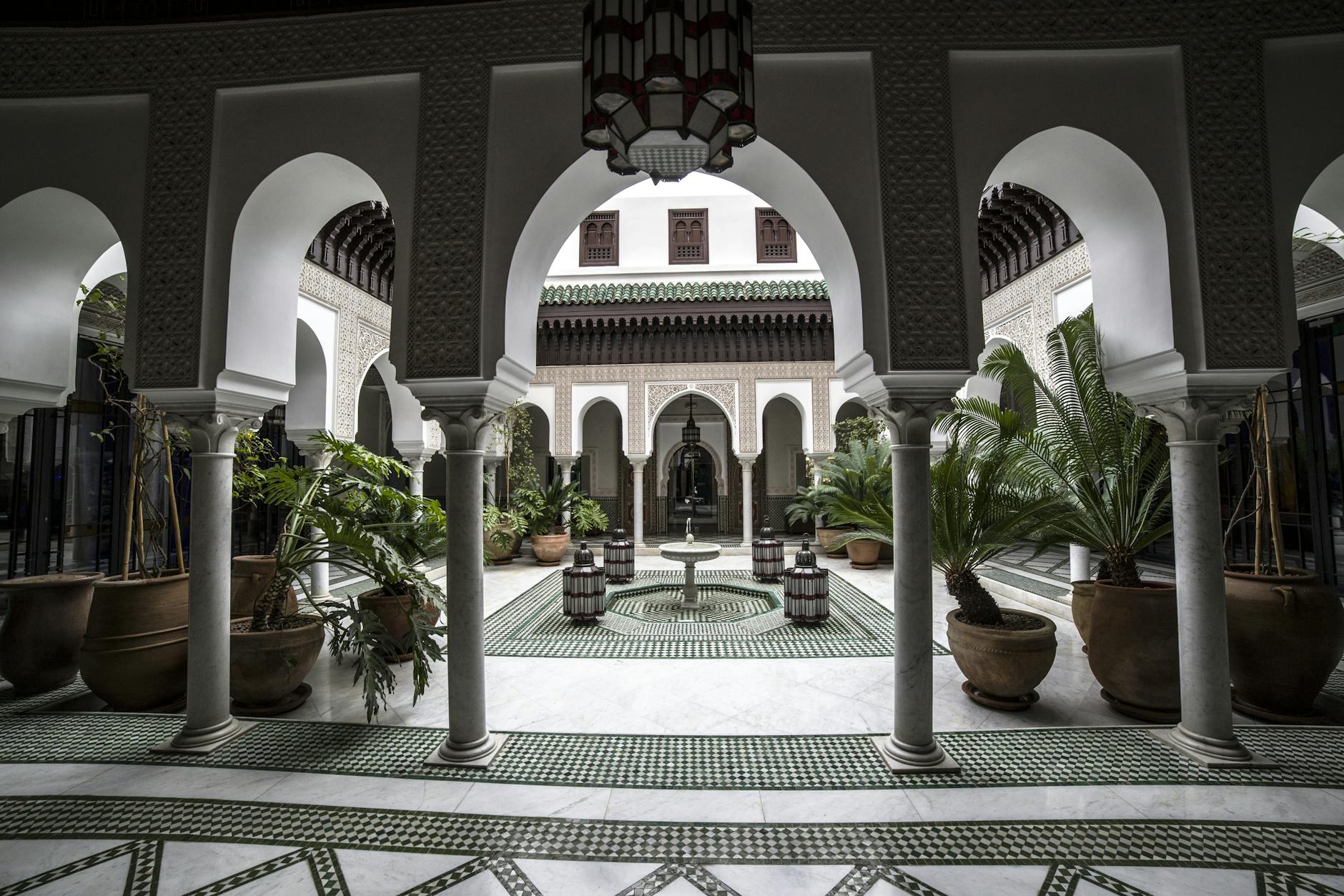 Quiet Moroccan courtyard with arches, fountain, and plants