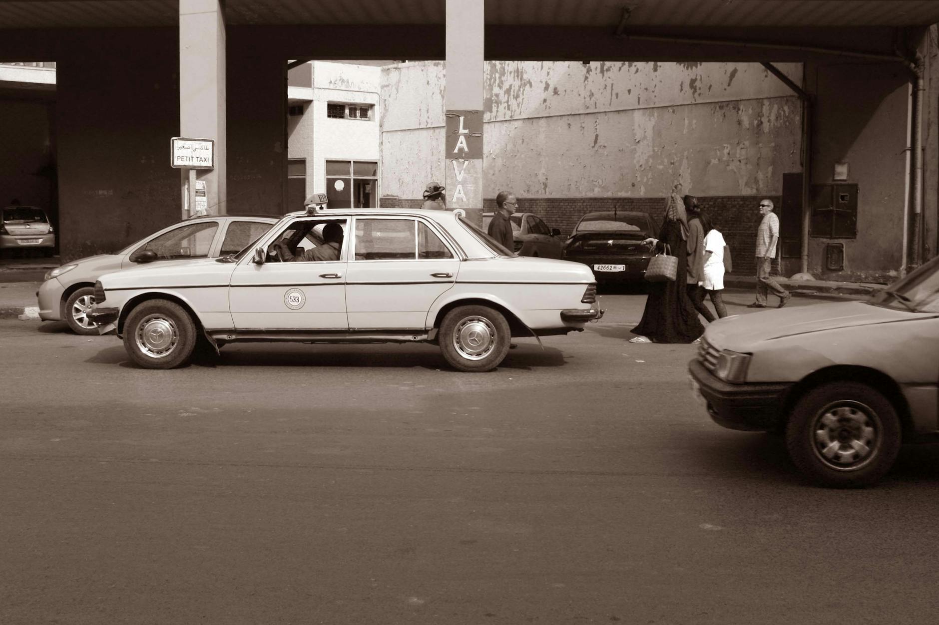 Vintage taxi on a Moroccan street with pedestrians