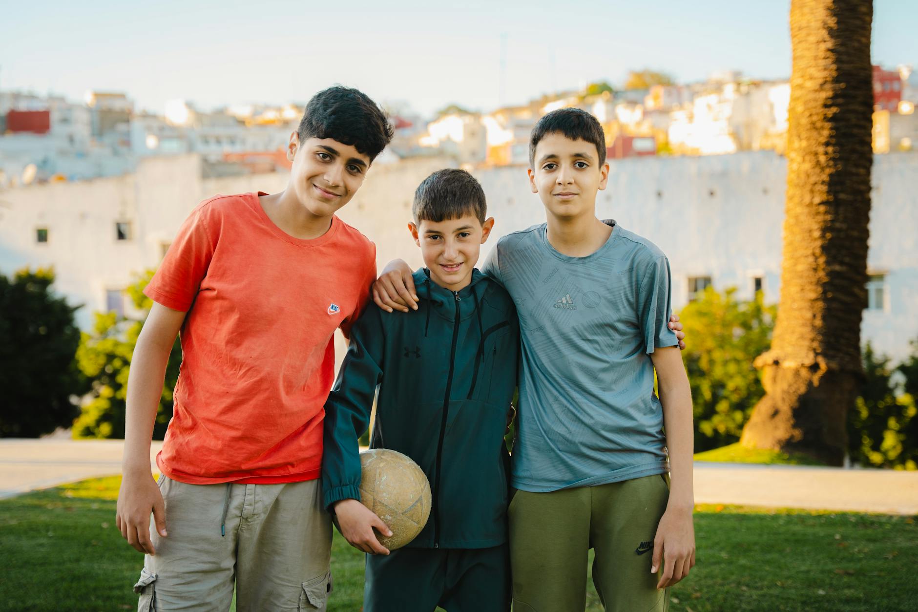 Three boys with a soccer ball in a park in Tanger, Morocco