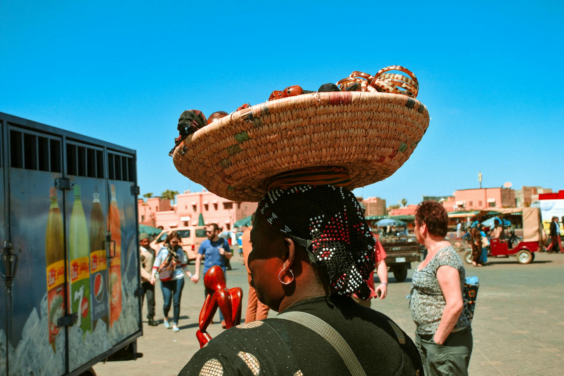 Outdoor market scene with a woman carrying a woven basket