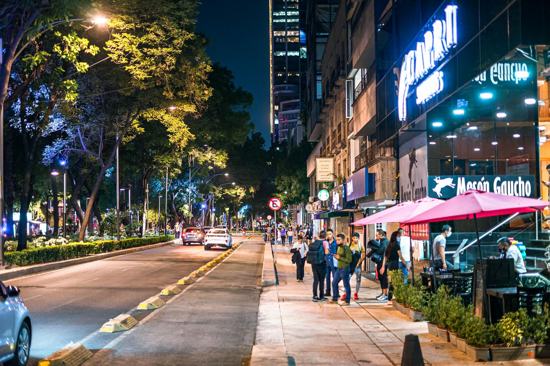 Lively Mexico City street with restaurants and pedestrians at night