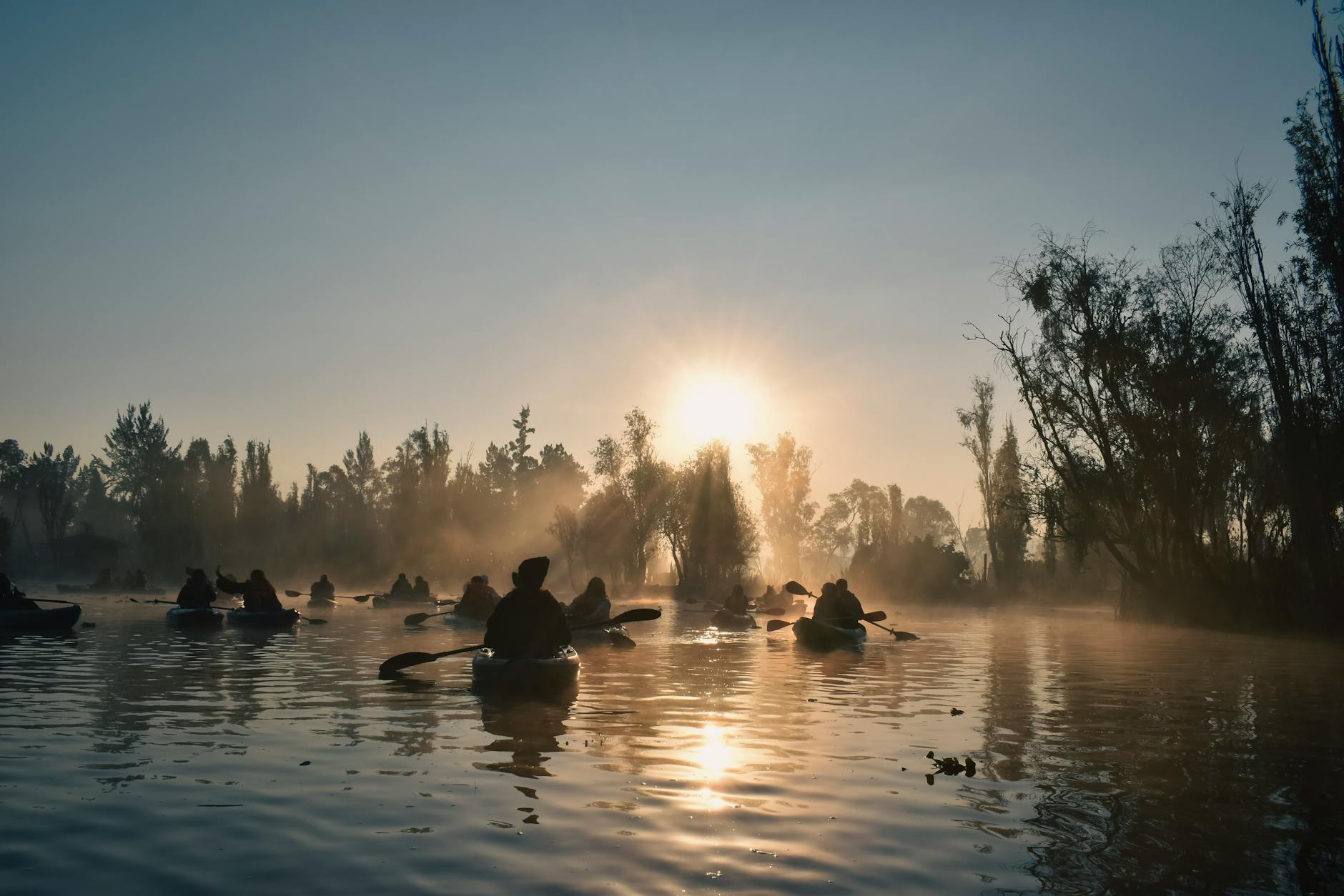 Kayakers paddling through Xochimilco canals at sunrise