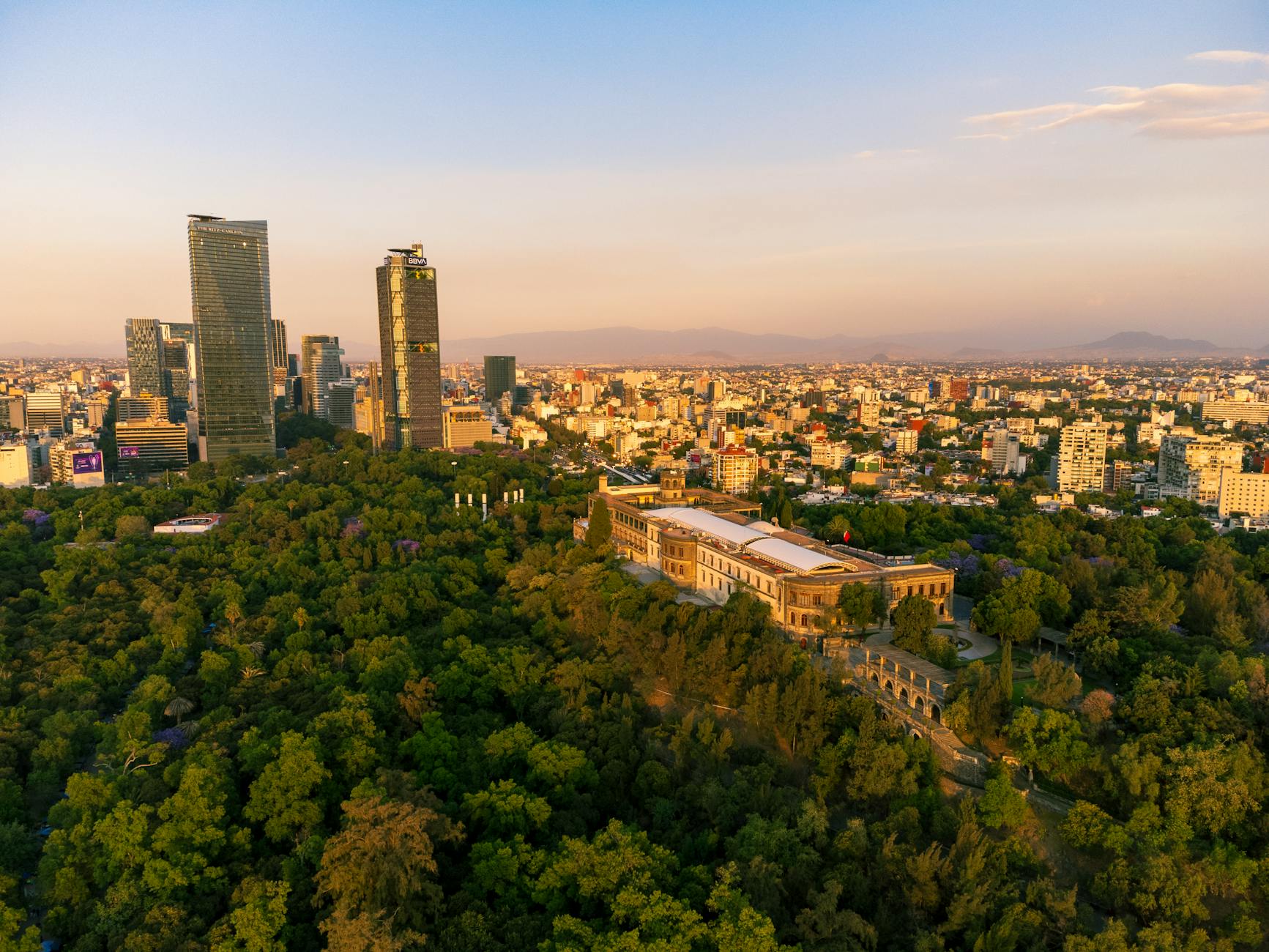 Chapultepec Castle surrounded by trees and Mexico City skyline