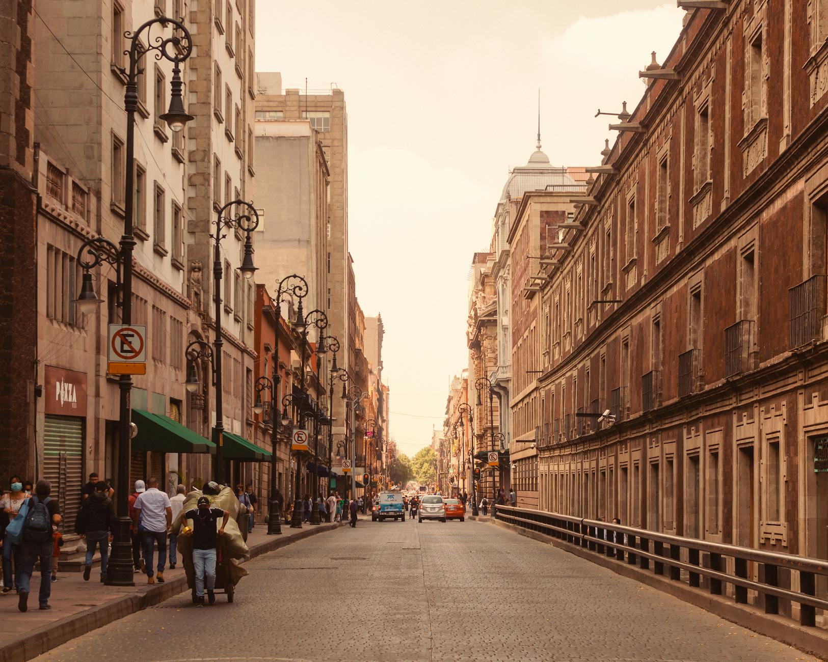 Pedestrians on a Mexico City street with historic architecture