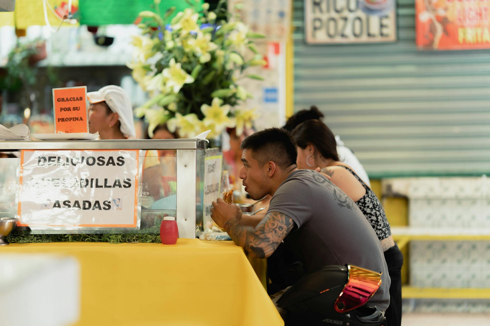 People eating at a Mexico City street food counter