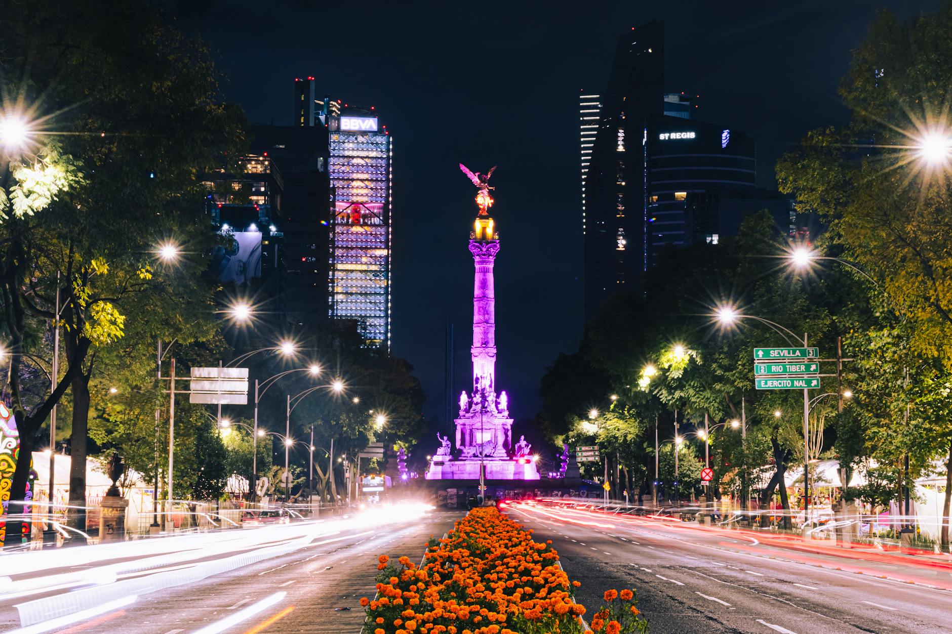 Angel of Independence illuminated at night on a busy Mexico City avenue