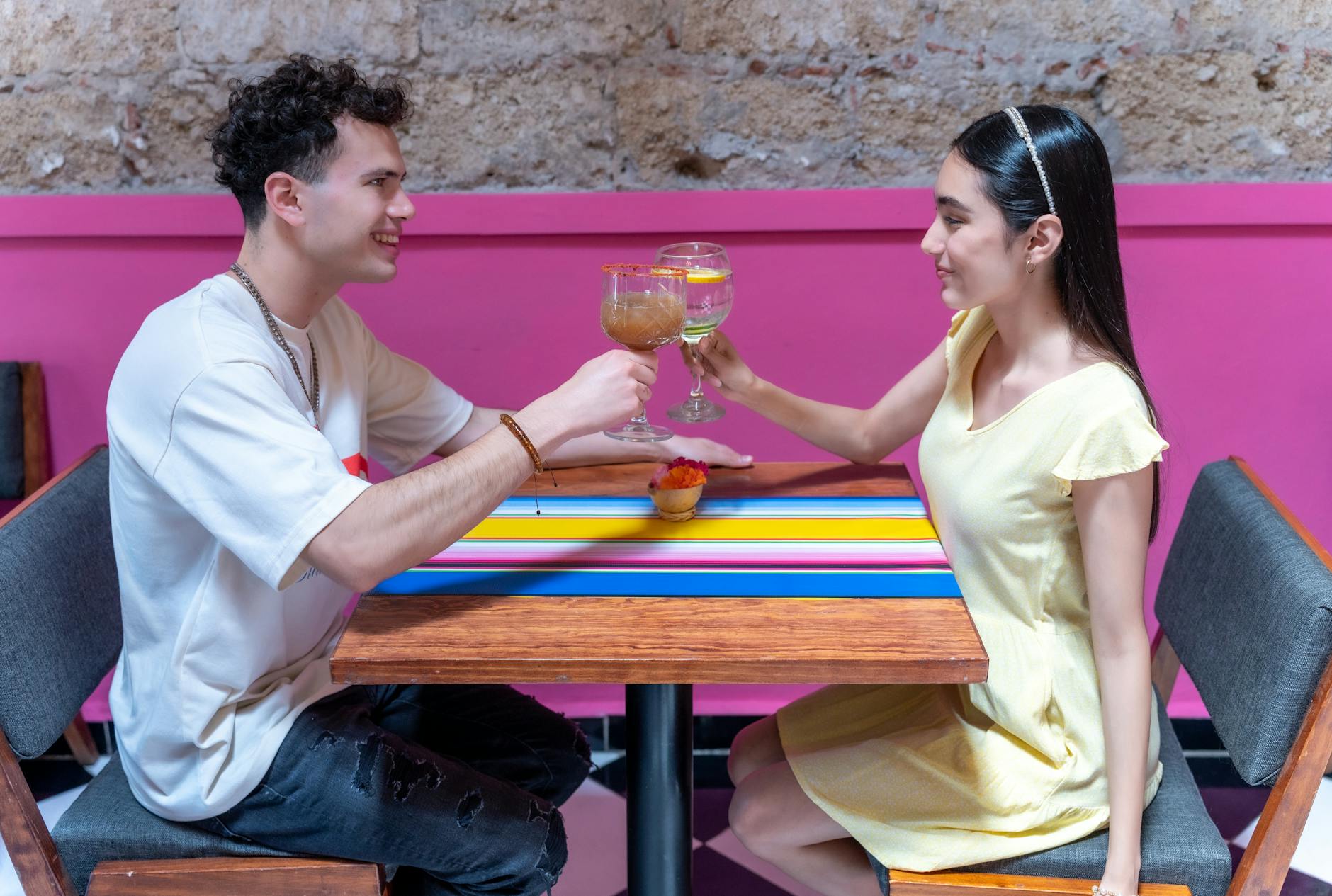 Couple toasting cocktails at a colorful restaurant in Mexico City
