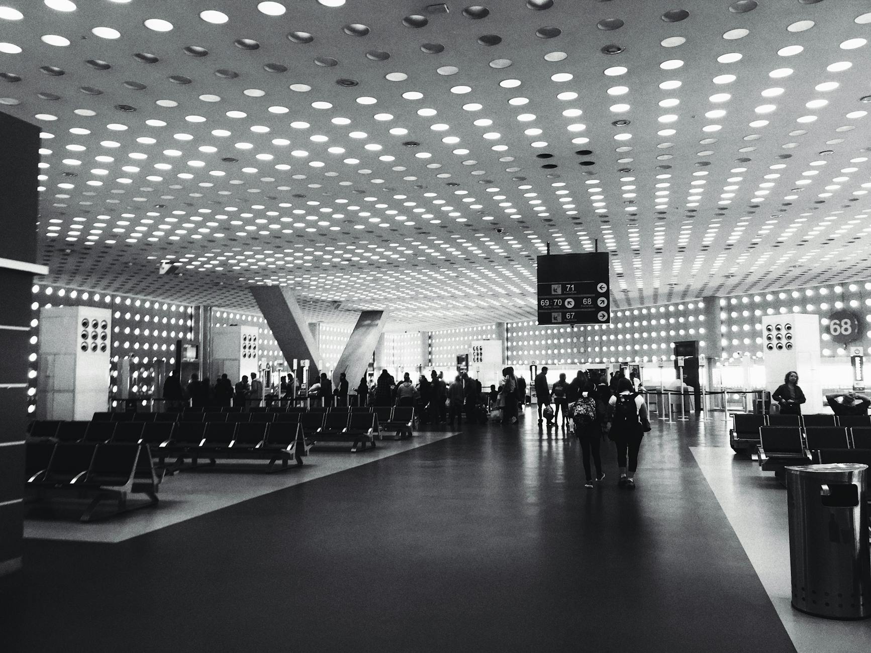 Travelers moving through a Mexico City airport lounge