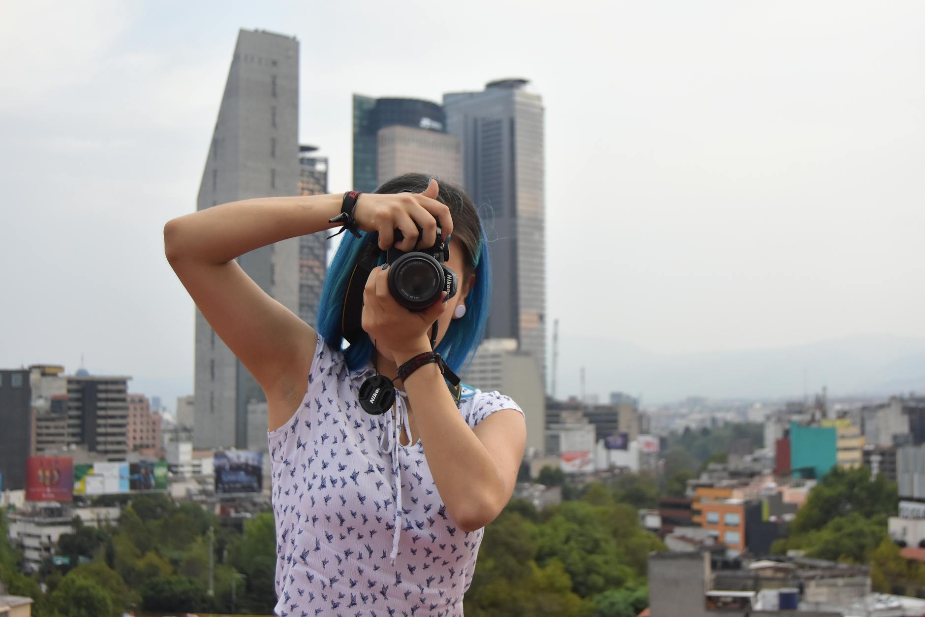 Woman photographing the Mexico City skyline with a camera