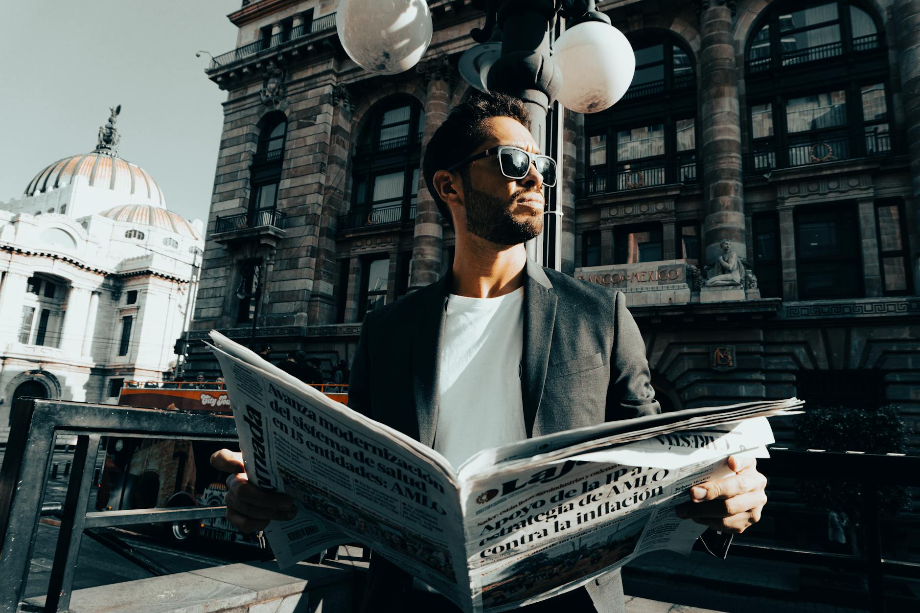Man reading a newspaper outside Palacio de Bellas Artes
