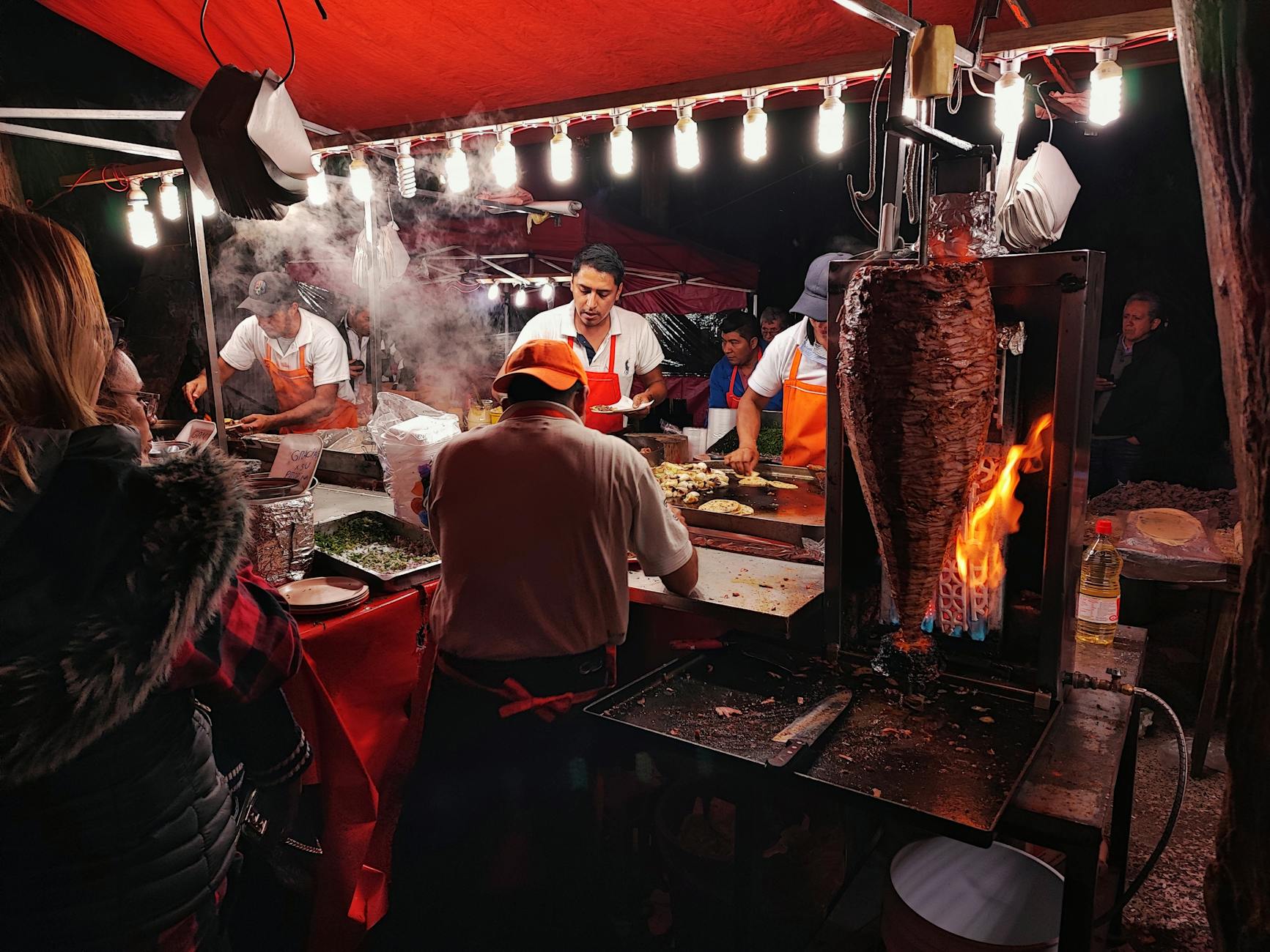 Mexico City nighttime street food stand preparing tacos al pastor