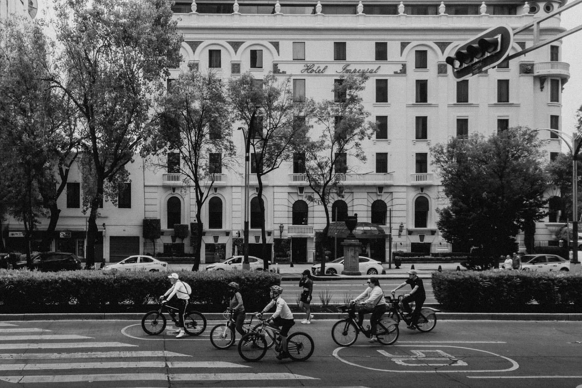 Cyclists passing the historic Hotel Imperial in Mexico City