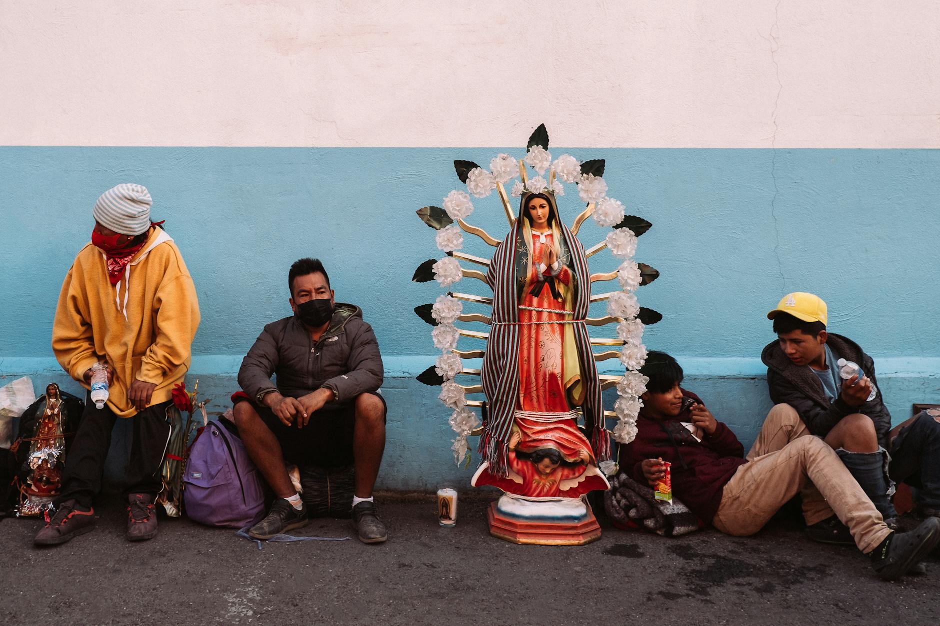 People near a statue of Our Lady of Guadalupe in Mexico City