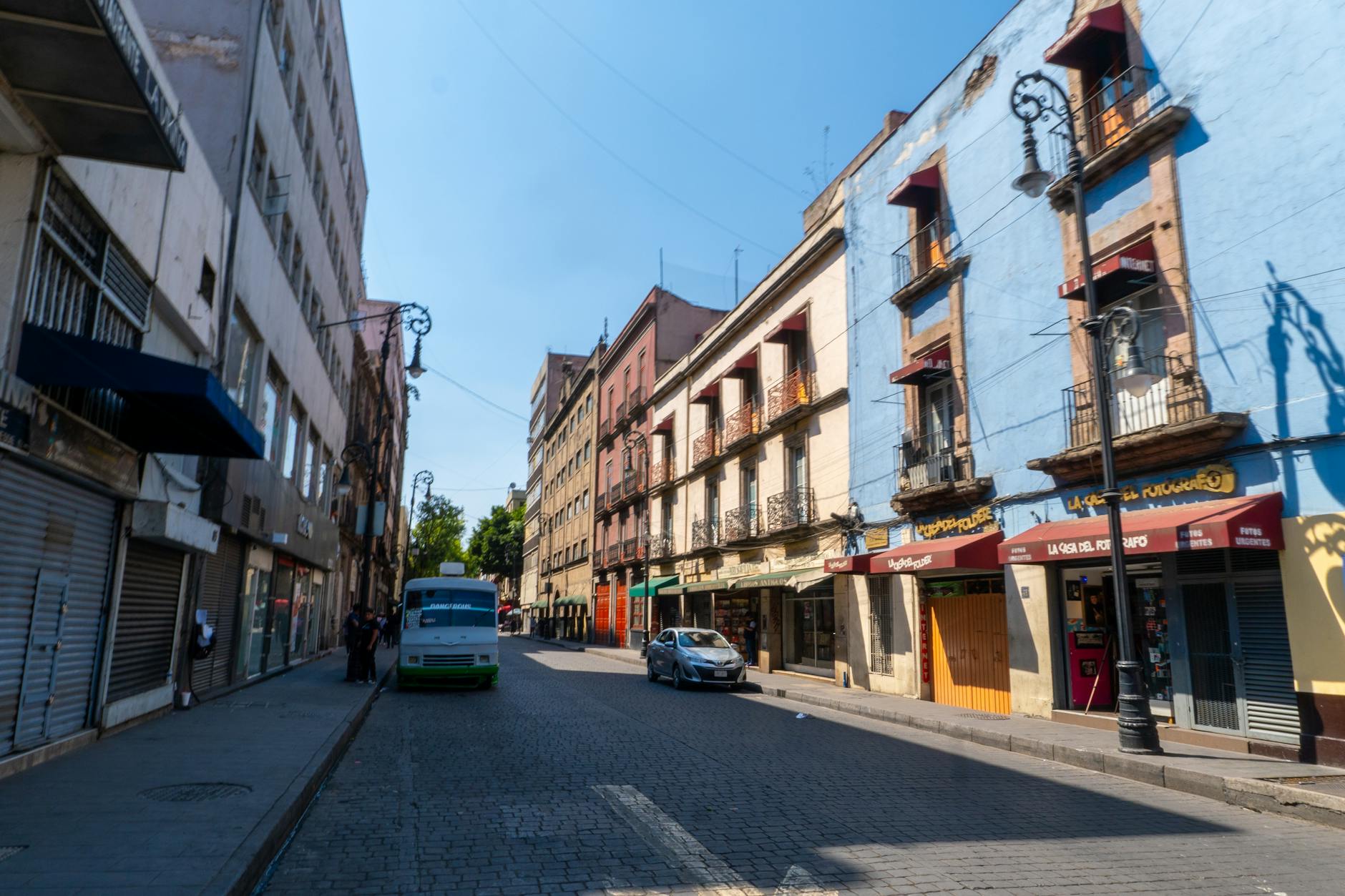 Colorful Mexico City street with parked cars and buildings
