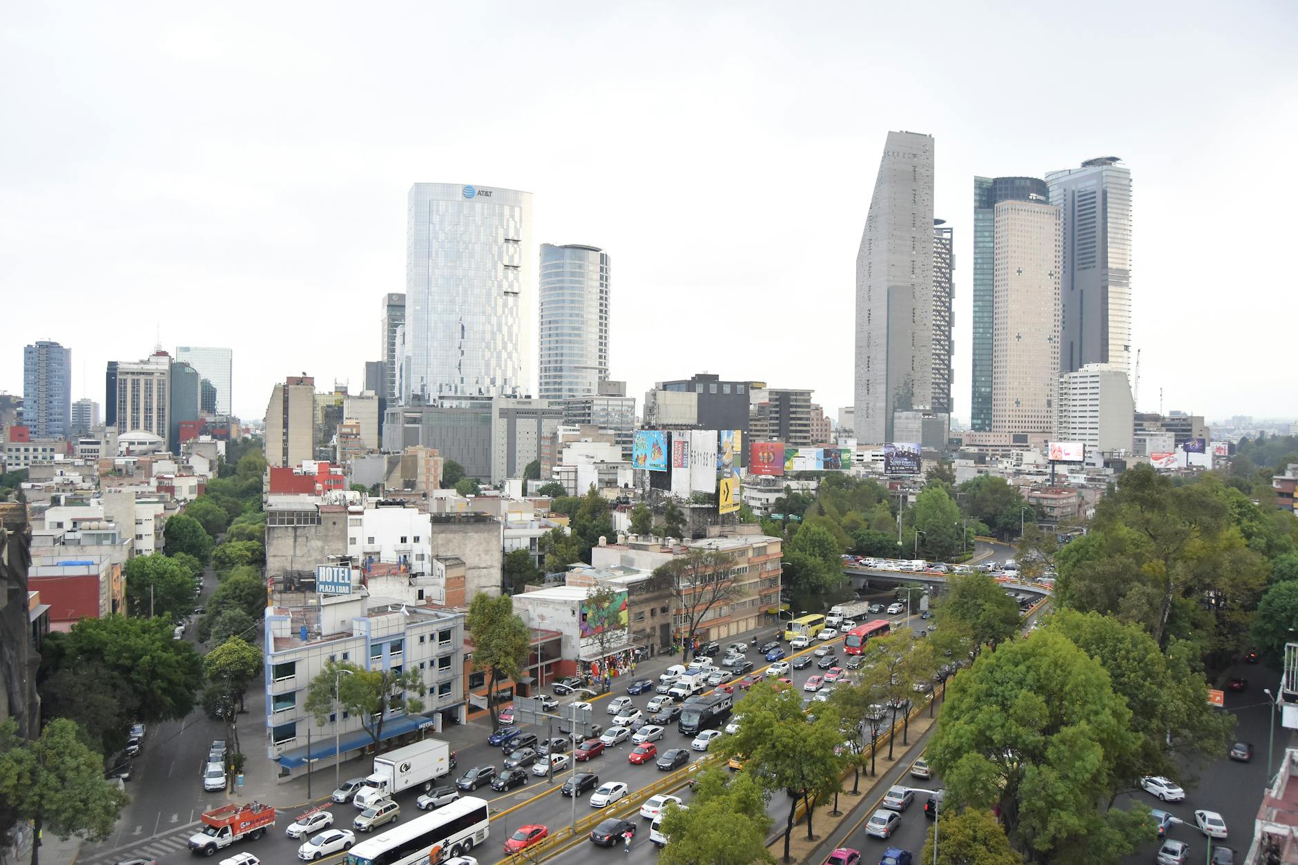 Mexico City street with traffic, greenery, and high-rise buildings