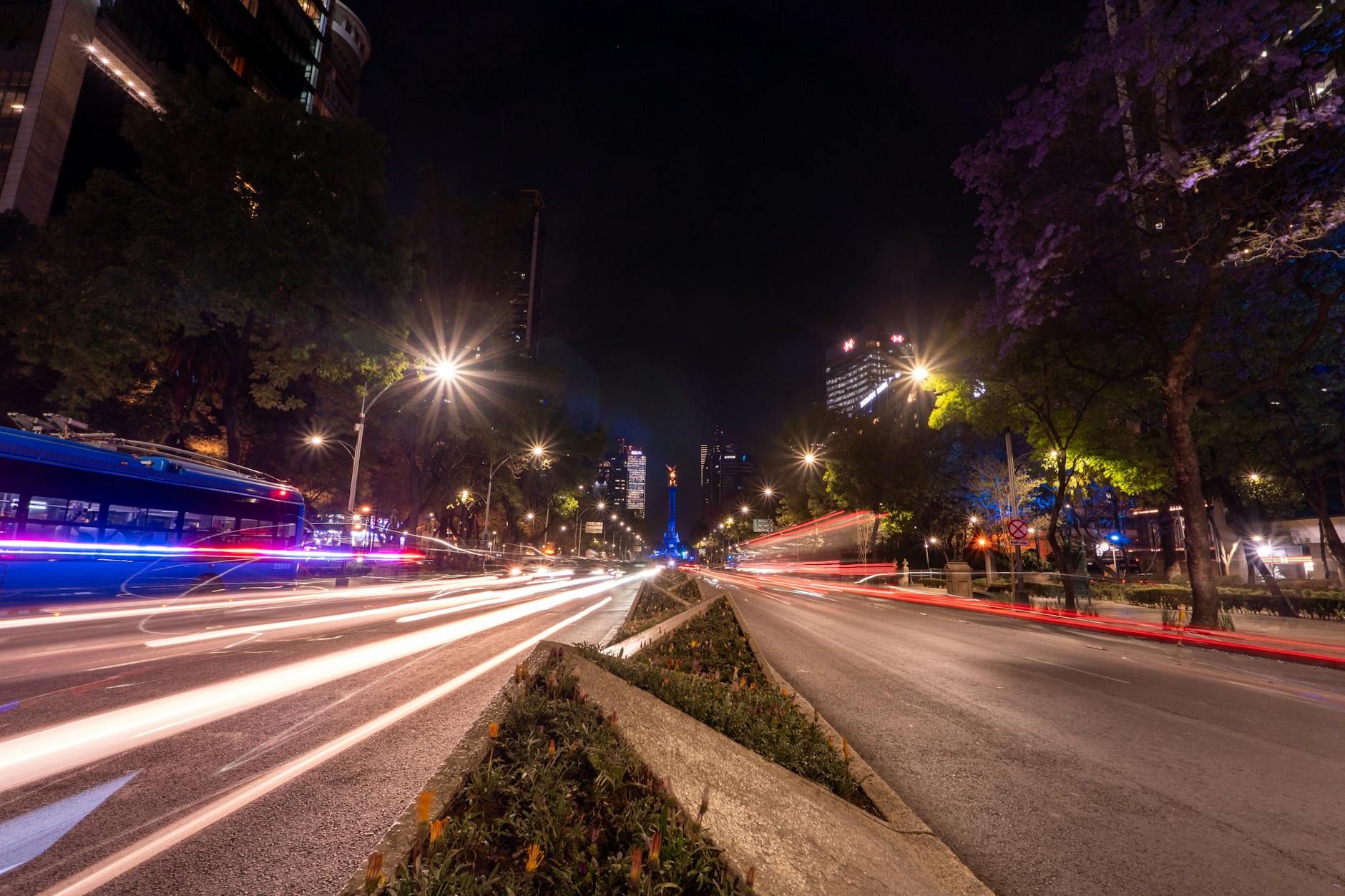 Mexico City night traffic and urban buildings with light trails