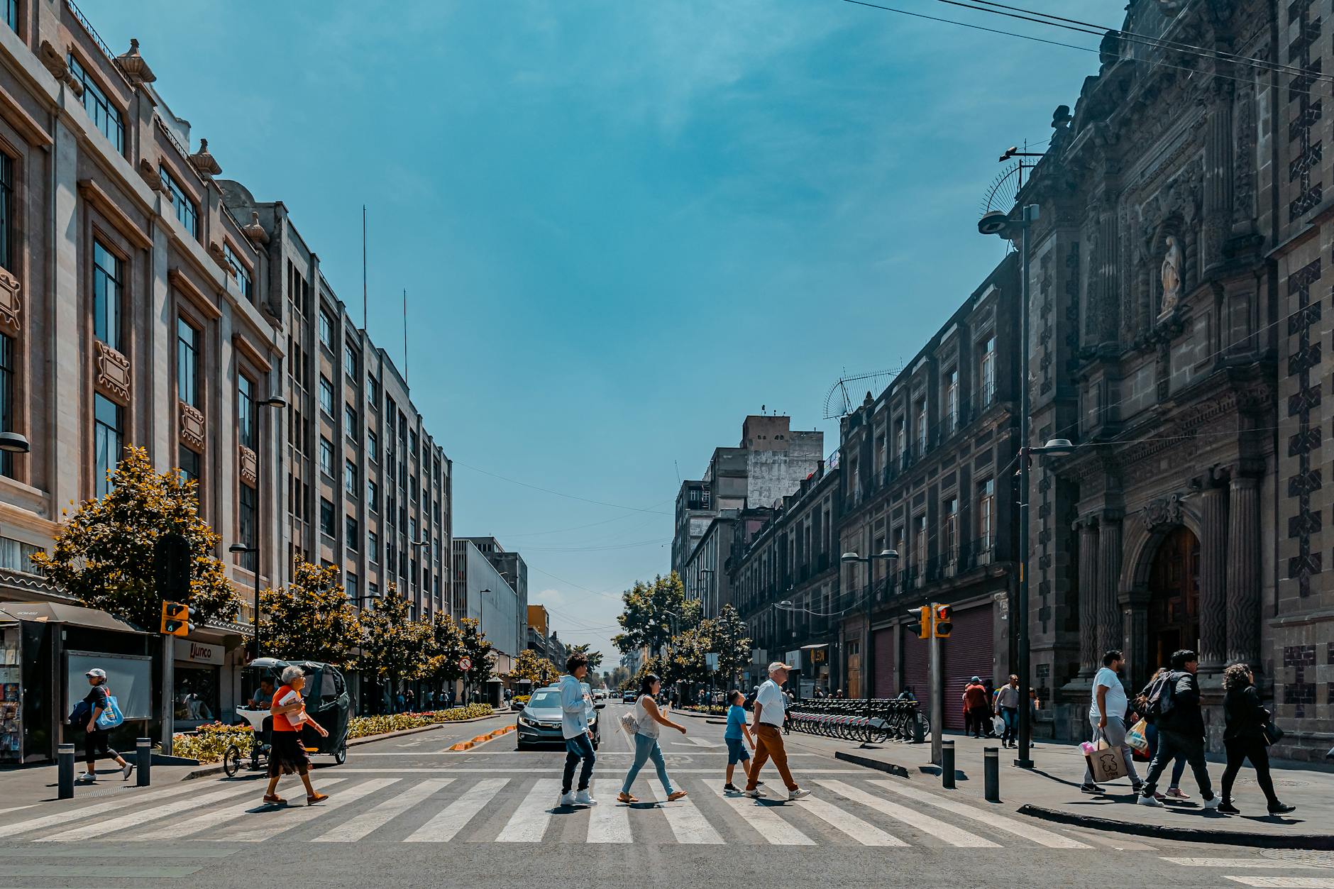 Pedestrians crossing a bright Mexico City street