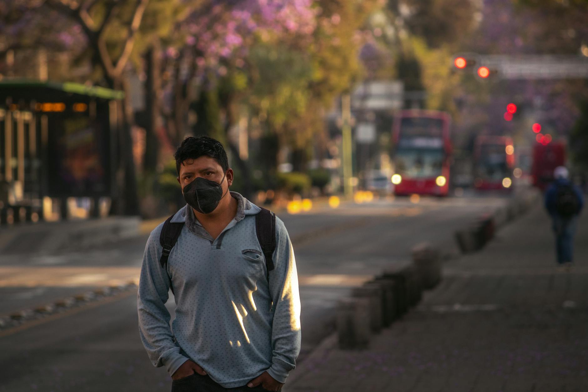 Masked pedestrian walking on a quiet Mexico City street