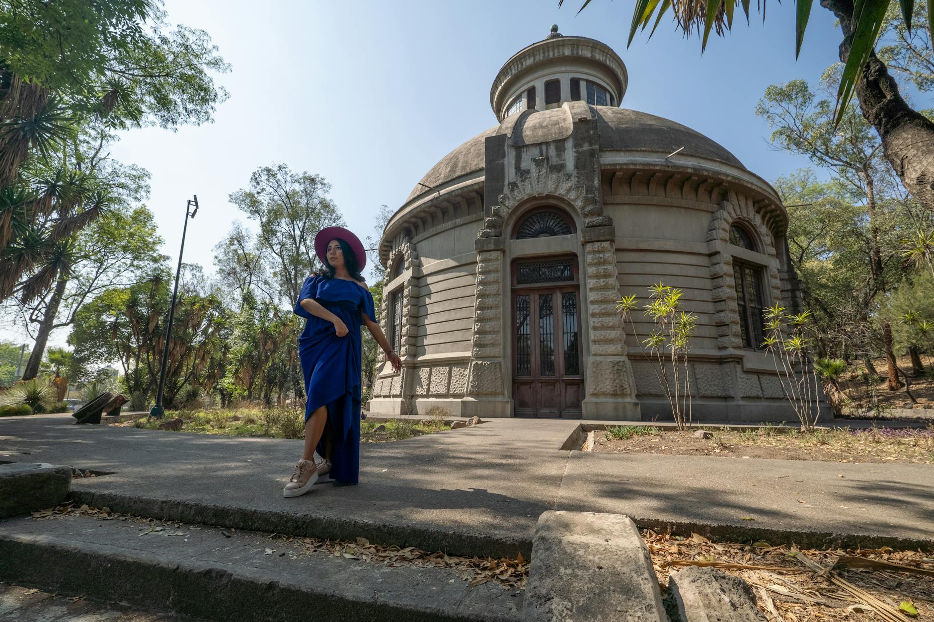 Woman in a blue dress walking through a Mexico City park