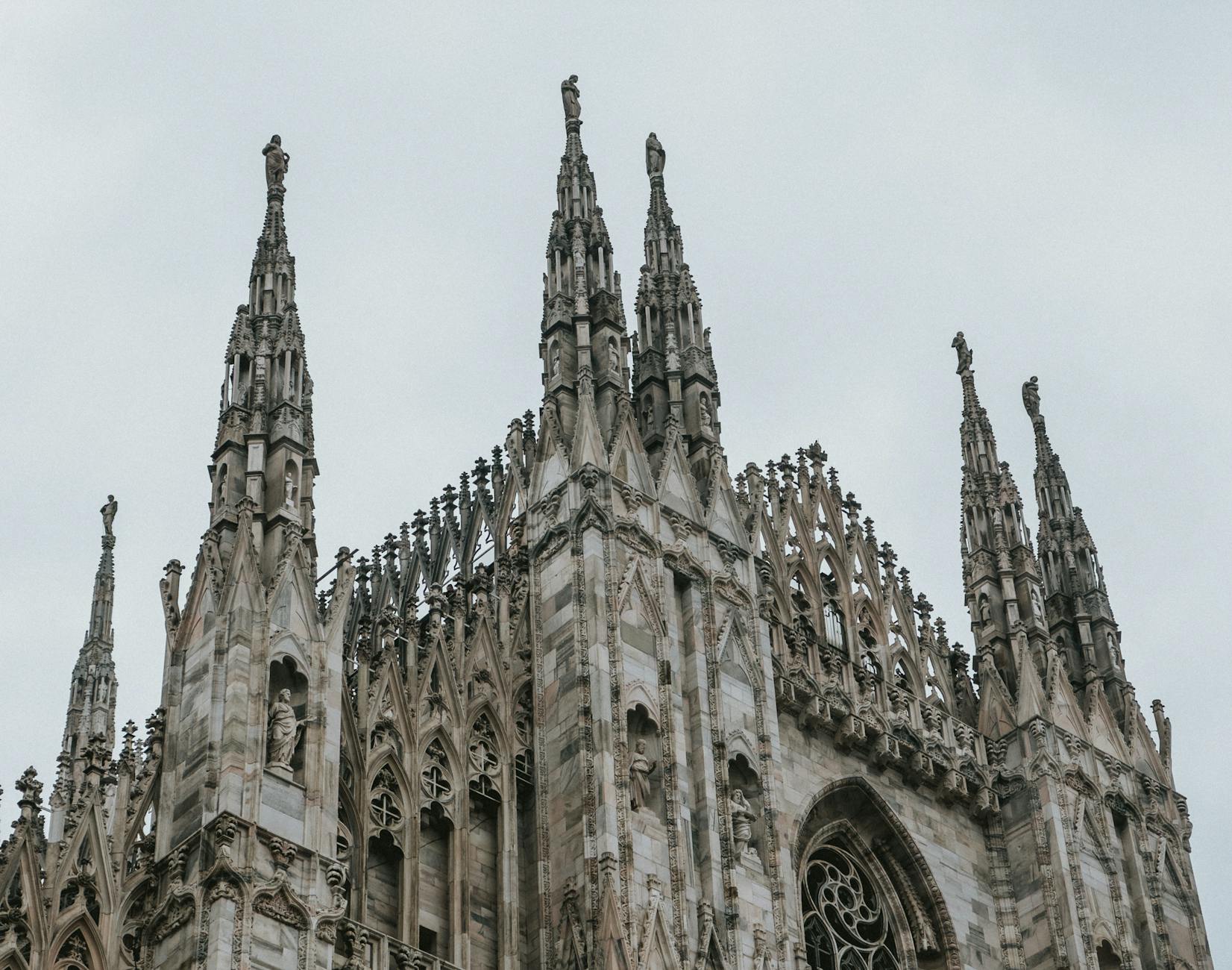 Gothic architecture of Milan Cathedral under an overcast sky