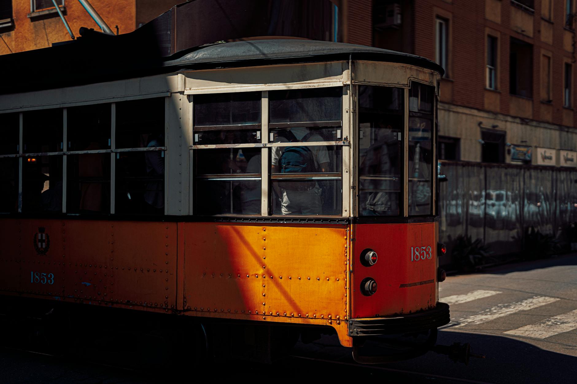 Orange tram on a sunny Milan street
