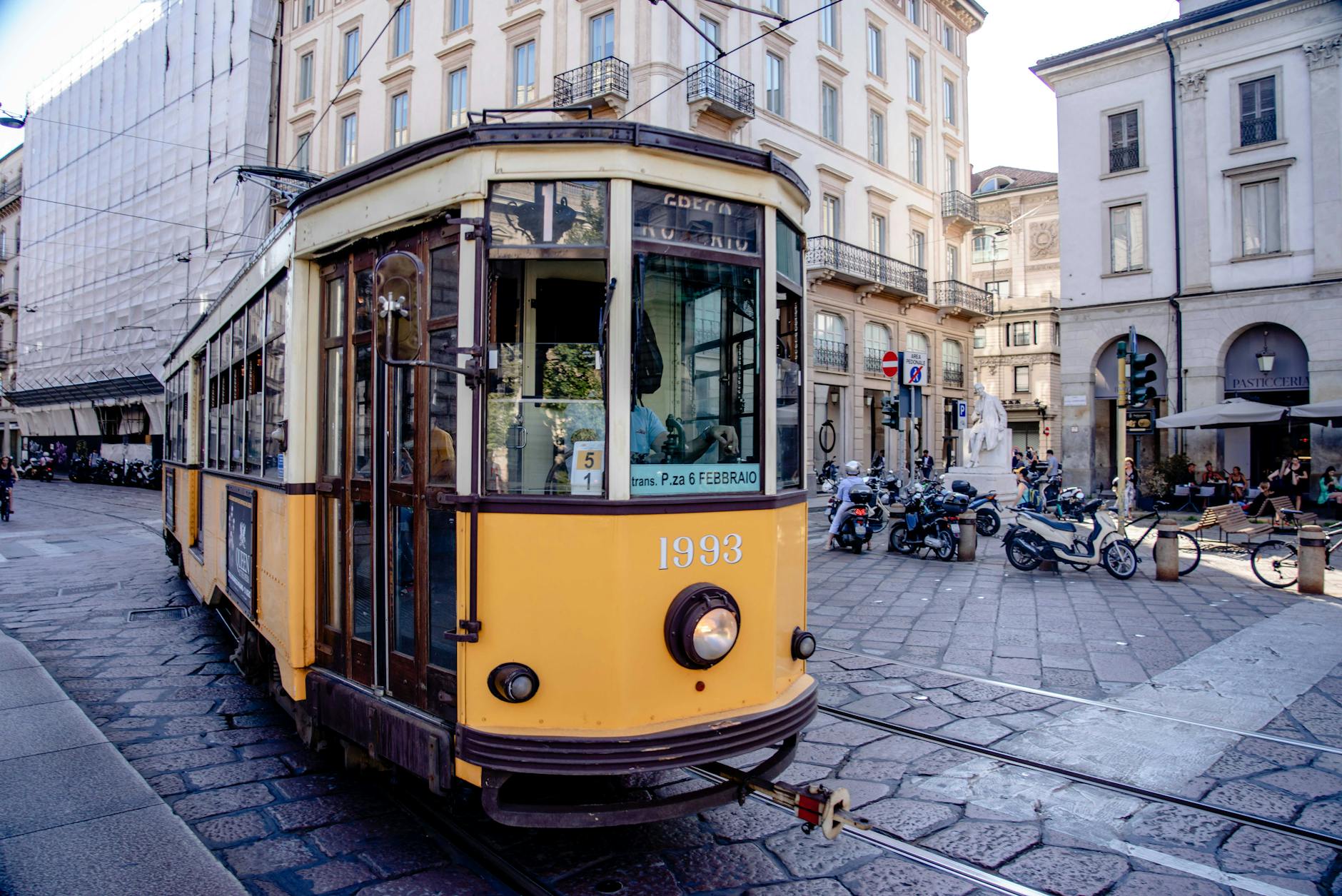 Yellow tram on a busy Milan street