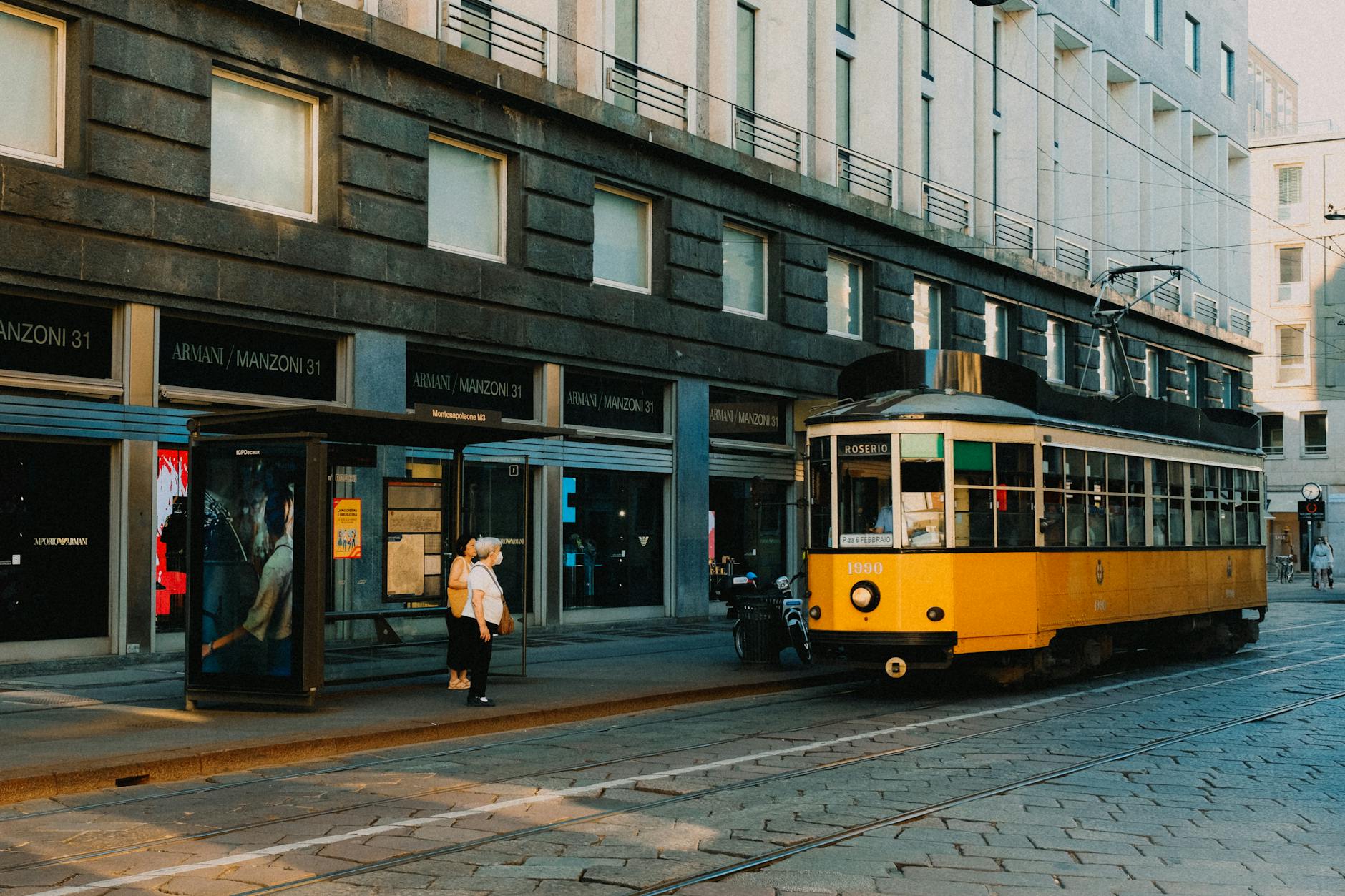 Yellow tram on tracks in downtown Milan