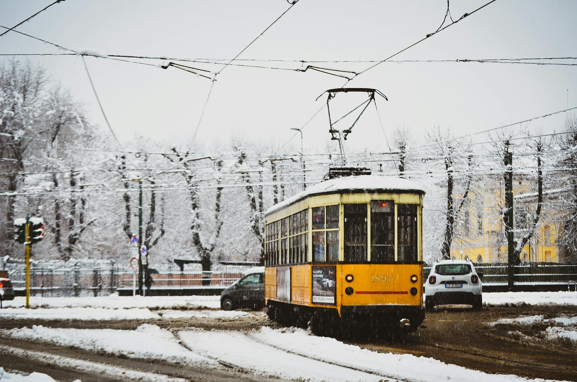 Cars and a yellow tram on a Milan street