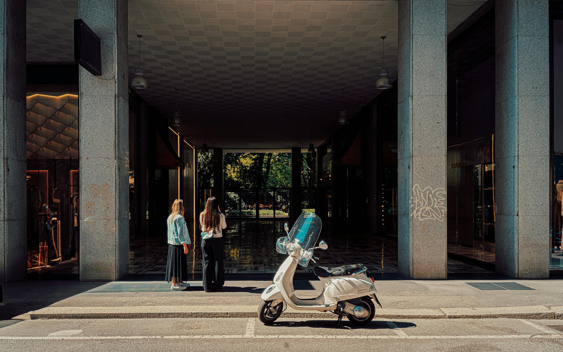 Women near a scooter on a Milan street