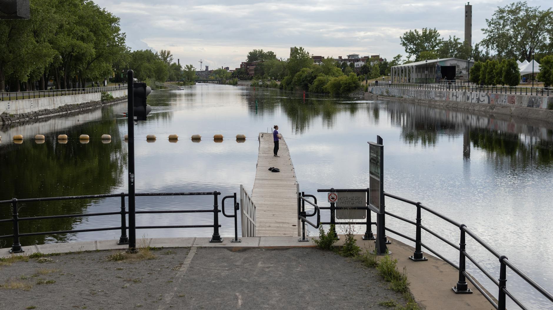Person fishing by an urban canal in Montreal