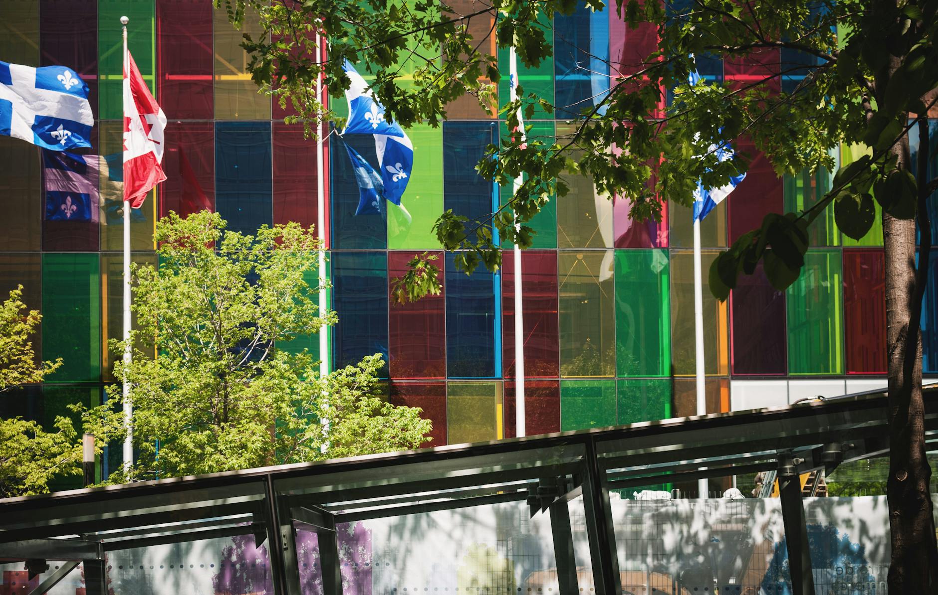 Glass building with Canadian and Quebec flags in downtown Montreal
