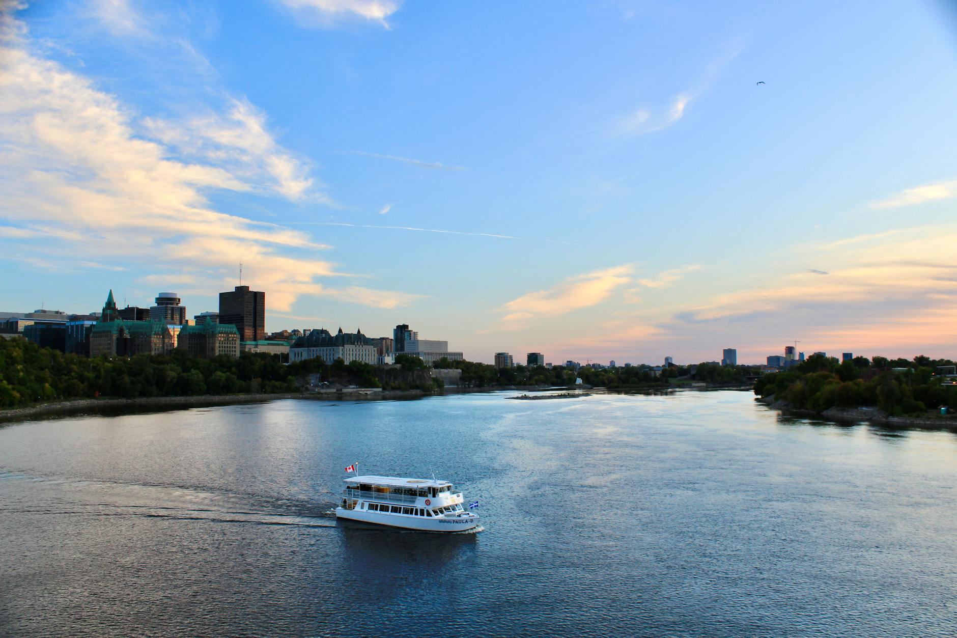 Touring boat on a river with skyline backdrop