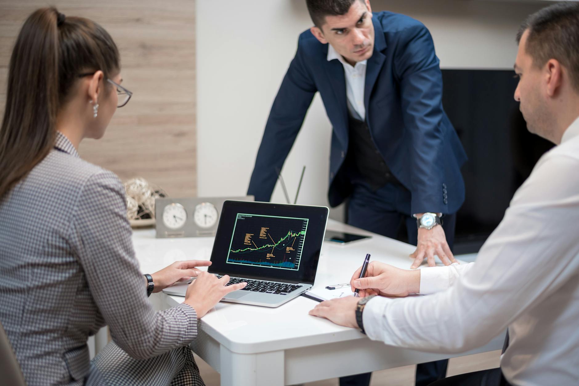 Team analyzing stock market trends on a laptop