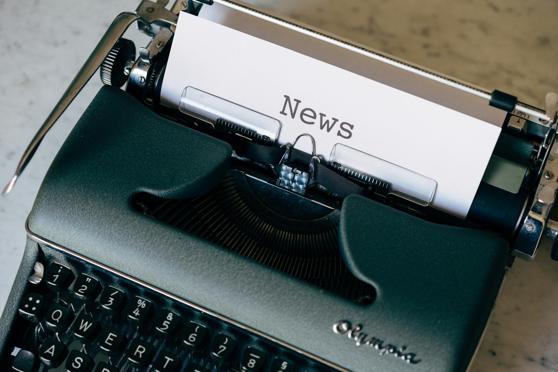 Typewriter with news written on paper
