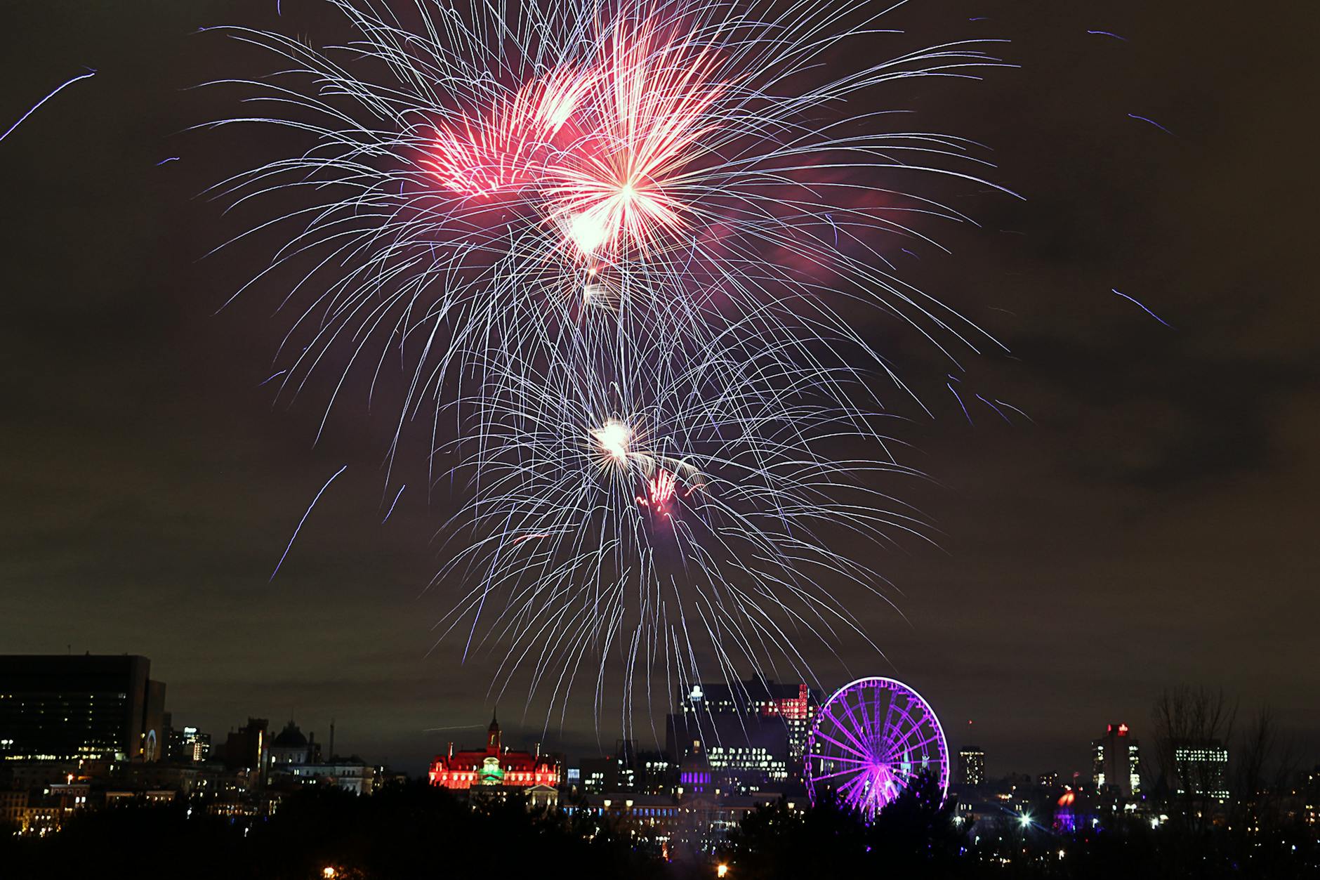 Fireworks over Montreal skyline and ferris wheel