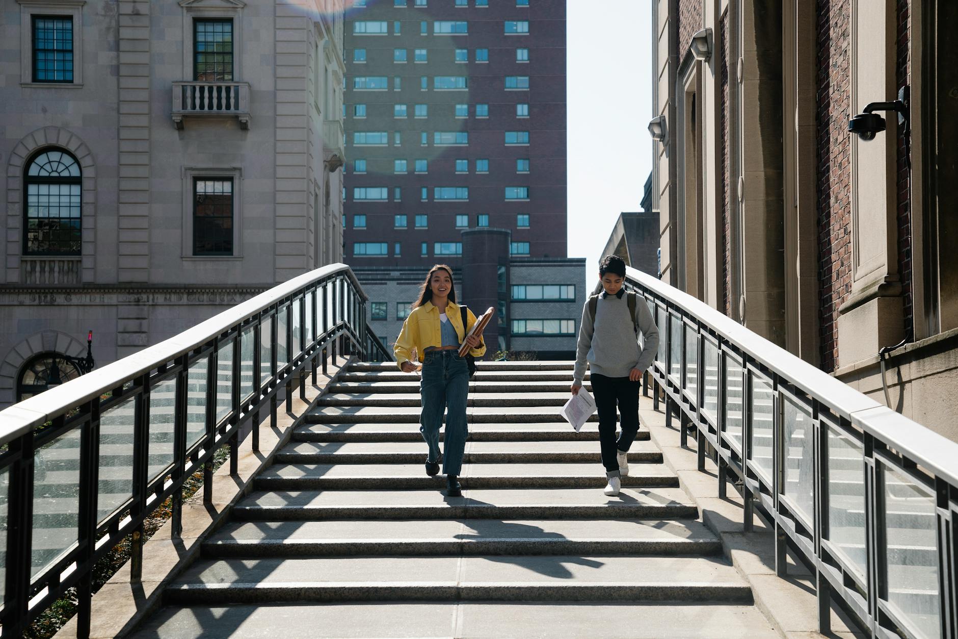 Students walking down university steps with notebooks