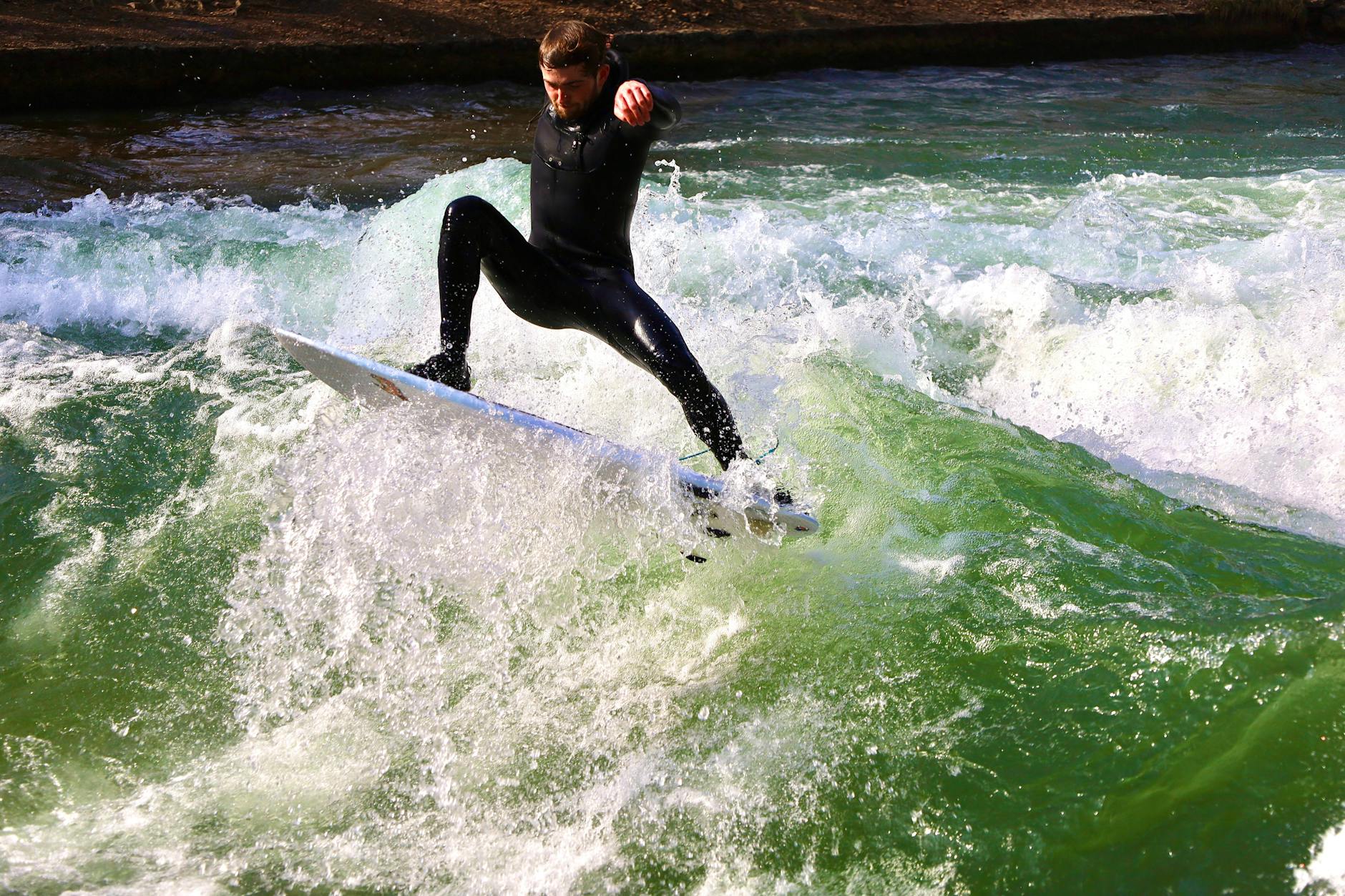 Surfer riding the Eisbach River wave in Munich