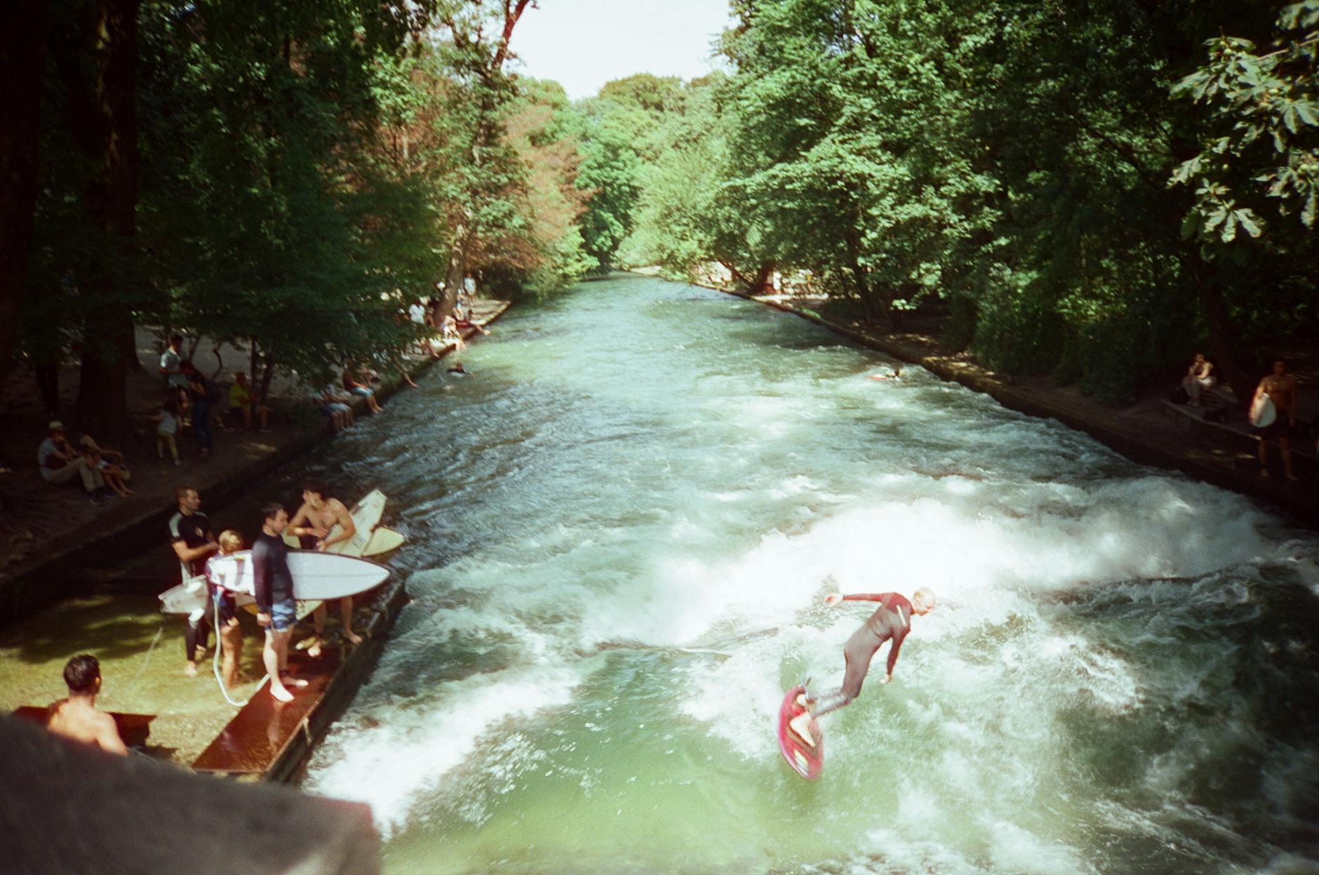 Surfers riding the Eisbach wave in Munich