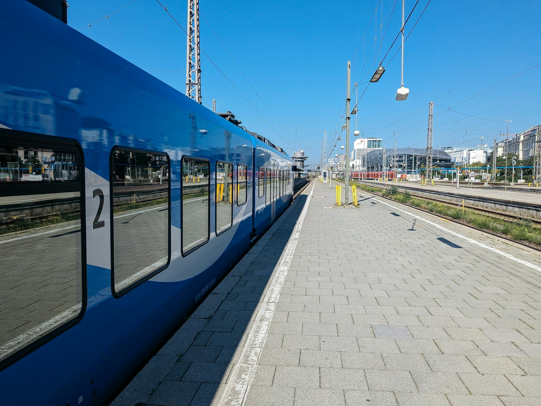 Blue train at an outdoor station platform in Munich