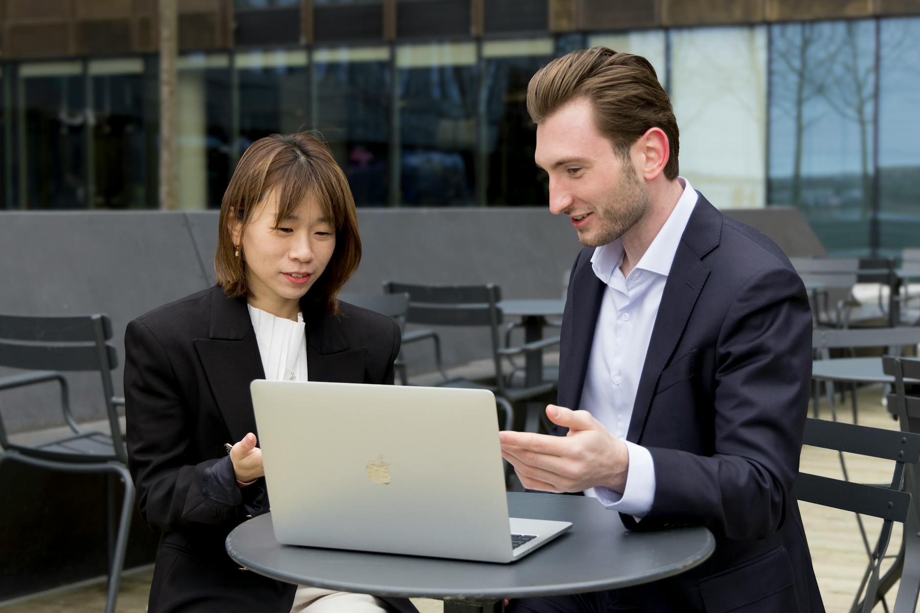 Professionals collaborating over a laptop outdoors