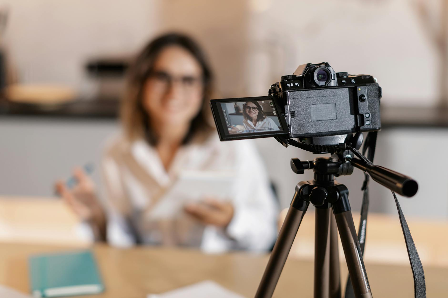 Vlogger using a camera and tripod indoors