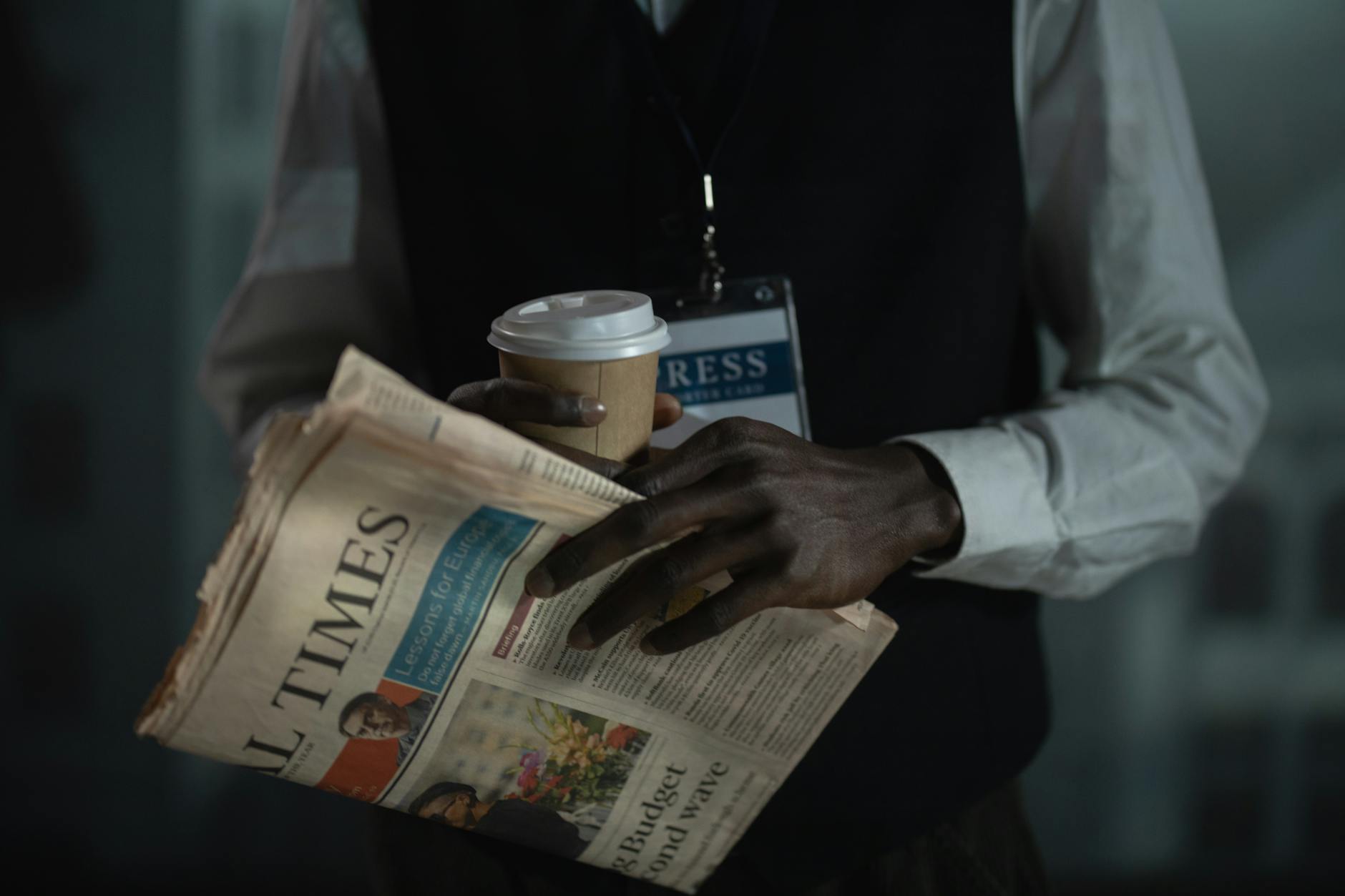 Journalist holding a newspaper and coffee