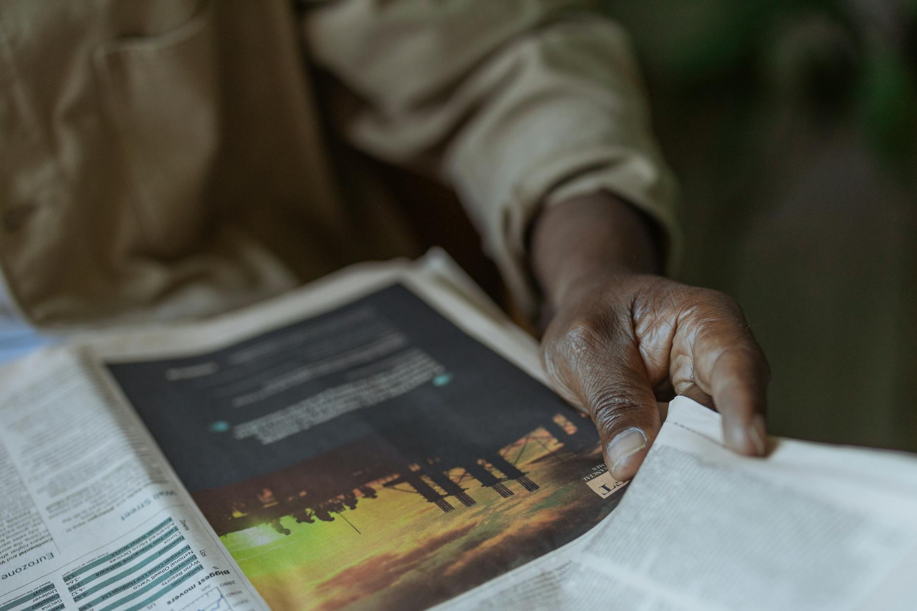 Person reading a newspaper indoors
