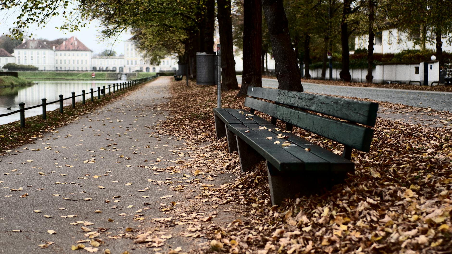 Bench and autumn path at Nymphenburg Palace park